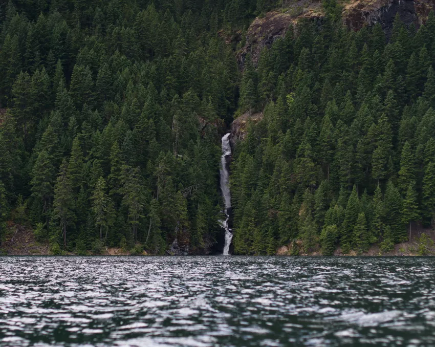 Beautiful waterfall surrounded by forest and ocean
